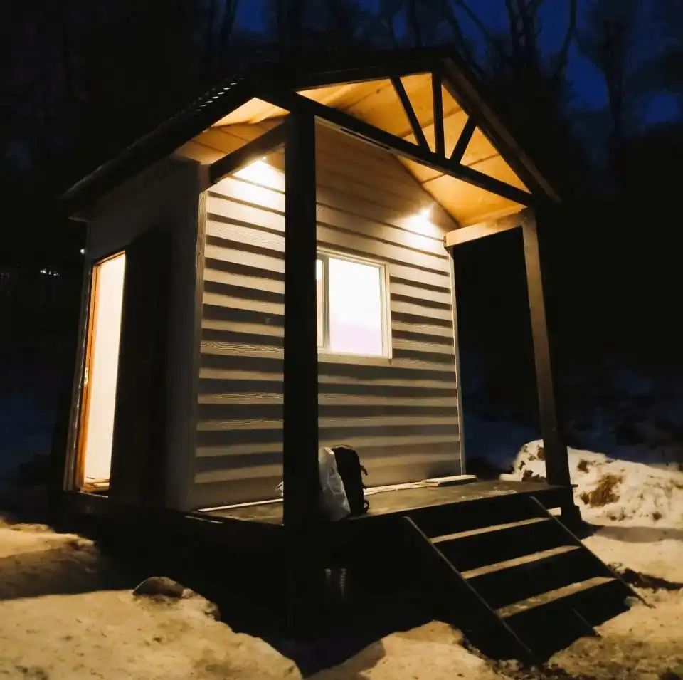 La garita iluminada al anochecer, un refugio cálido en el ingreso al Jardín Botánico